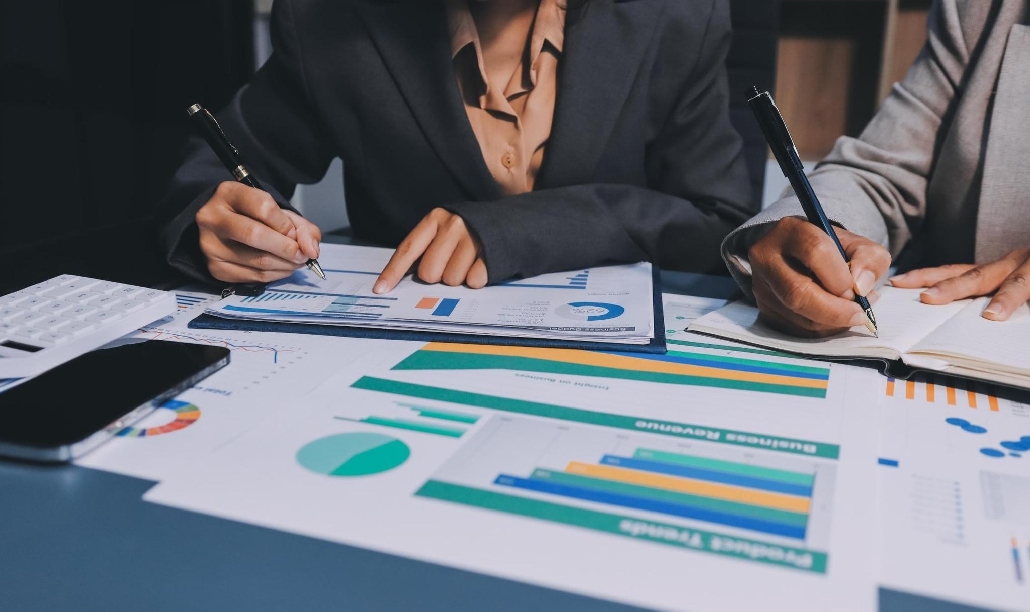 Business professionals reviewing audit reports and financial charts.