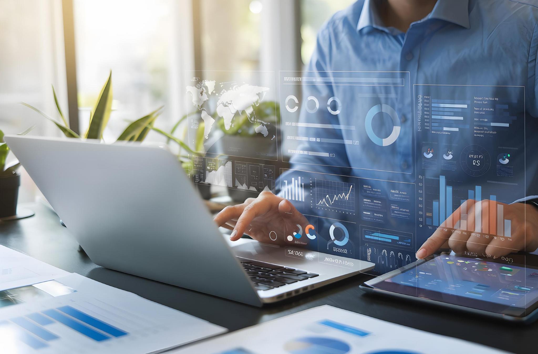 Business professional analyzing data dashboards on laptop and tablet.