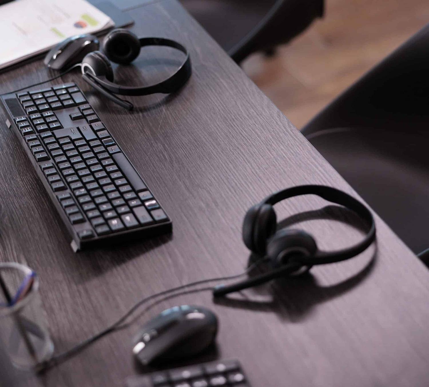 Desk with headset and keyboard for virtual bookkeeping tasks.