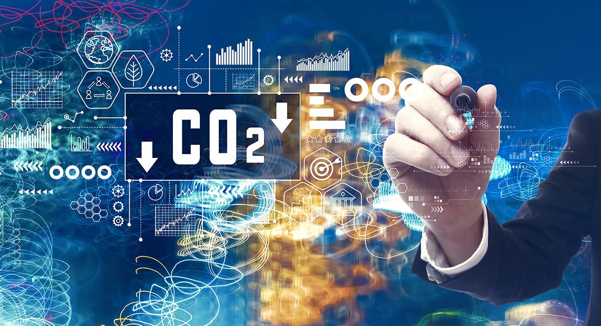 Hand pointing to CO2 reduction graphics representing ESG data.